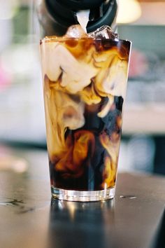 a drink with ice and liquid is sitting on a table