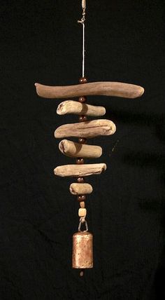 a wind chime made out of driftwood and wood with a bell hanging from it