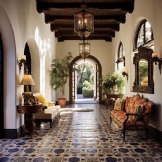 a hallway with an arched doorway leading to another room filled with furniture and potted plants