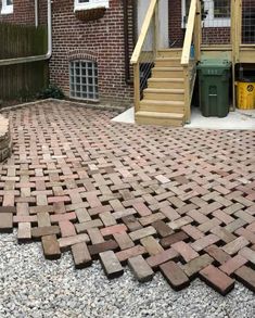 a brick patio with steps leading up to the front door