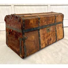 an old wooden trunk sitting on top of a white floor next to a garage door