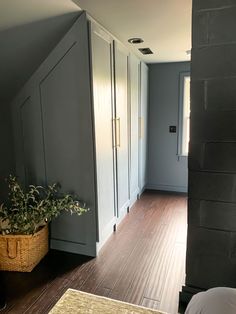 an empty room with gray walls and wooden flooring is pictured in this image from the doorway