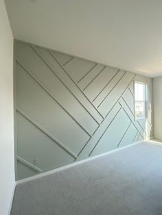 an empty room with white walls and grey carpet