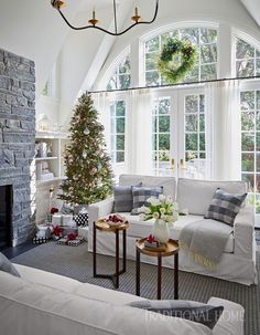 a living room filled with furniture and a christmas tree in front of a large window