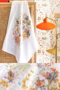 two pictures of towels hanging on the wall next to a lamp and table with flowers