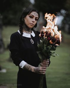 a woman holding a bouquet of flowers in her hands with flames coming out of it