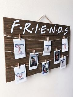 a wooden sign hanging on the wall with photos hung to it's sides and friends written on them