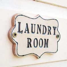 a sign that says laundry room on the side of a building in front of a door