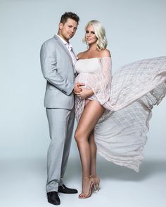 a man in a suit and woman in a white dress posing for a photo together