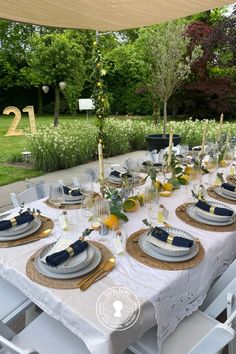 the table is set with plates and silverware for an elegant dinner party in the garden