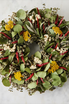 a wreath with red, yellow and green flowers on it sitting on a marble surface