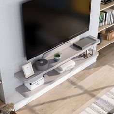 a flat screen tv sitting on top of a white entertainment center next to a book shelf