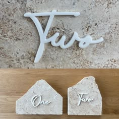 two pieces of stone sitting on top of a wooden table next to the word yes