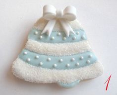 a cookie decorated like a christmas tree with white and blue frosting on it's side