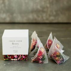 three bags filled with flowers sitting next to each other on a counter top in front of a box