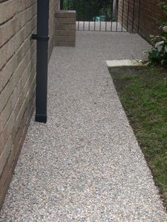 a walkway between two brick buildings next to grass