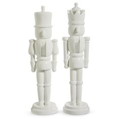 two white ceramic nutcrackers standing next to each other on a white background