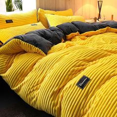 a bed with yellow and black comforters on it