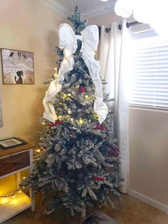 a christmas tree decorated with white bows and lights