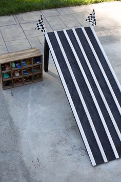 a black and white striped board laying on the ground next to a box with bottles in it