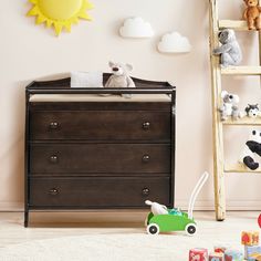 a baby crib with toys in it and a ladder to the wall behind it