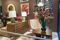 a living room filled with lots of furniture and flowers in a vase on top of a table