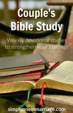 an open bible sitting on top of a wooden table next to a stack of books