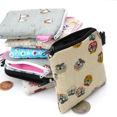 several small zippered pouches sitting on top of each other next to a penny