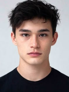 a close up of a person wearing a black shirt and looking at the camera with a serious look on his face