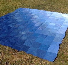 a blue patchwork blanket laying on the grass