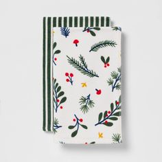 two napkins on top of each other with holly leaves and berries printed on them