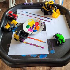 children's art table with construction vehicles and paper on it