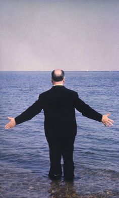 a man standing in the water with his arms outstretched