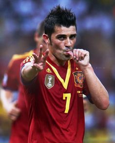 a soccer player making the peace sign with his hand