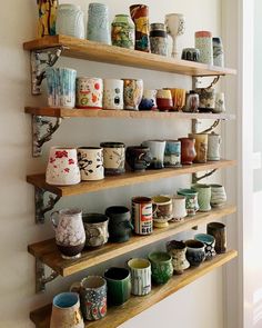 several shelves filled with different kinds of pottery