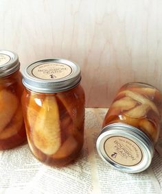 three jars filled with pickles sitting on top of an open book