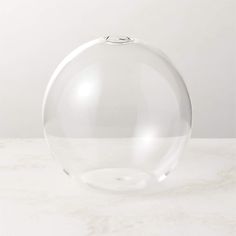 a clear glass vase sitting on top of a white countertop next to a wall