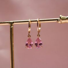 Our Pink Crystal Earrings feature natural pink zircon stones set in hypoallergenic gold over brass. With stainless steel hooks, they're also gentle on sensitive skin. Lightweight and comfortable, these earrings are perfect for everyday wear, offering a simple yet elegant design that sparkles in the light. * Stainless Steel * Skin-friendly * Lever back Hooks * Made in Texas Cheap Pink Dangle Clip-on Earrings, Cheap Pink Casual Earrings, Affordable Modern Pink Earrings, Cheap Pink Sterling Silver Earrings, Disney Princess Earrings, Dream Earrings, Pink Crystal Earrings, Pink Zircon, Pink Paradise