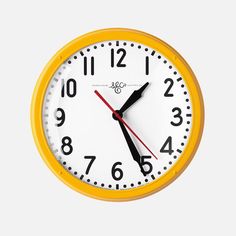 a yellow and white clock with black hands