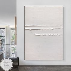 a large white painting hanging on the side of a wall