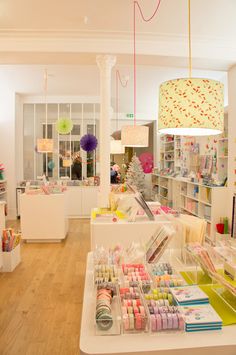 the inside of a store with lots of items on display and lights hanging from the ceiling