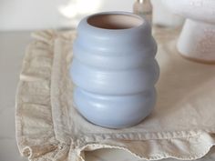 a blue vase sitting on top of a table next to a white toilet paper roll