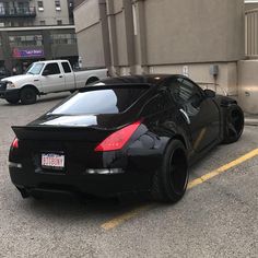 a black sports car parked on the side of the road in front of a building