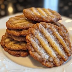 several cookies on a white plate with powdered sugar