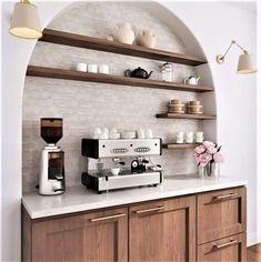 a coffee machine sitting on top of a counter next to a wall filled with shelves