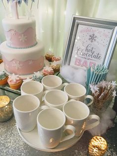 a table topped with lots of cups and cakes