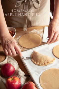 a woman is making homemade pies on a table with apples and other ingredients around her