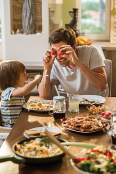 a man and child sitting at a table with food