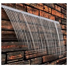 an old brick building with a white metal vent on it's side and wood planks in the background