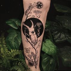 a black and white tattoo on the leg of a person with an animal in it